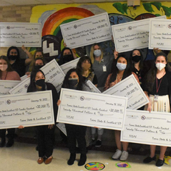 education students holding giant checks