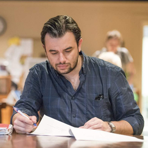 man sits at table with paper and pen